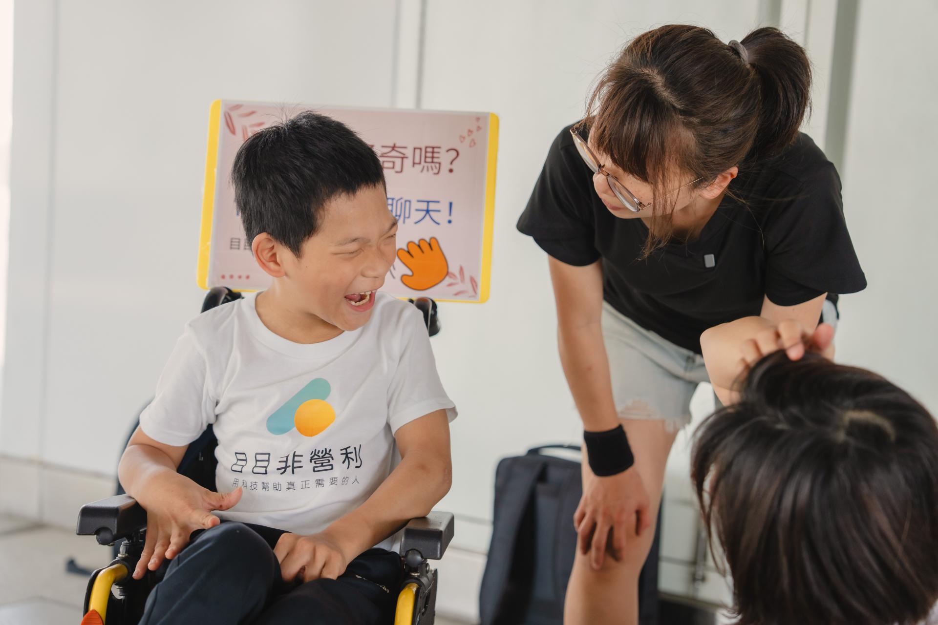 戶外教學前，凱玫老師自製打招呼牌子：「對我好奇嗎？快來跟我聊聊天！目目眼動小學員生活實踐」放置在朋寯的輪椅上，期待打開孩子與大眾之間的溝通橋樑。